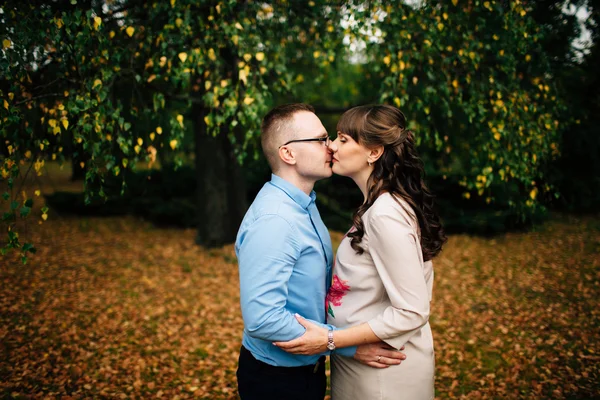 Young beautiful pregnant woman and her handsome husband kissing. — Stock Photo, Image