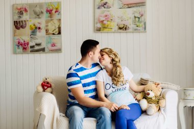 Hamile bir kadınla çift birlikte kanepede dinleniyor..