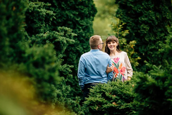 Pregnant beautiful woman and her handsome husband lovely hugging in autumn park. — Stock Photo, Image