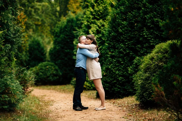 Embarazada hermosa mujer y su apuesto marido precioso abrazo en otoño parque . —  Fotos de Stock