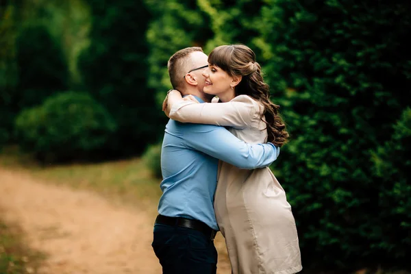 Pregnant beautiful woman and her handsome husband lovely hugging in autumn park. — Stock Photo, Image