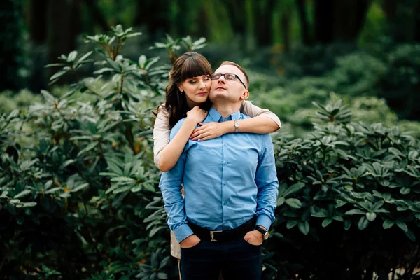 Embarazada hermosa mujer y su apuesto marido precioso abrazo en parque . — Foto de Stock