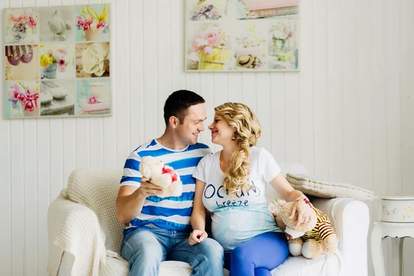 Par med gravid kvinna avkopplande på soffan tillsammans. — Stockfoto