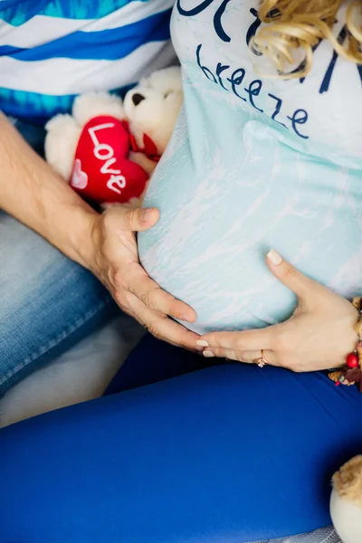 Föräldrar hålla händerna på magen på den gravida modern. — Stockfoto