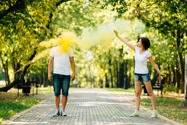 Jovens e bonitos, casal hipster brincando no parque no festival de cores holi com pó de tinta a cores . Fotografias De Stock Royalty-Free