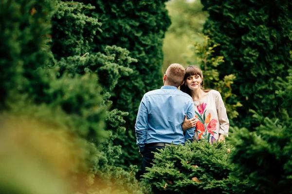 Embarazada hermosa mujer y su apuesto marido precioso abrazo en otoño parque . —  Fotos de Stock