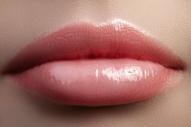 Yakın çekim güzel kadın dudakları parlak lipgloss makyaj ile. Temiz cilt mükemmel, taze dudak makyaj ışık. Güzel spa makro ihale pembe ruj ile vurdu. Spa ve kozmetik