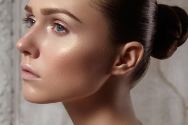 Mükemmel temiz parlak deri, doğal moda makyaj güzel genç kadın. Glamour model şirin topuz saç modeli ile portresi. Yakın çekim kadın, taze spa bak