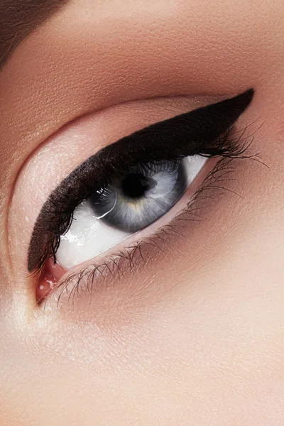 Macro de primer plano de hermoso ojo femenino con cejas de forma perfecta. Piel limpia, maquillaje natural de moda. Buena visión. Maquillaje clásico del delineador de ojos de moda. Lápiz de ojos negro y sombras de ojos marrones —  Fotos de Stock