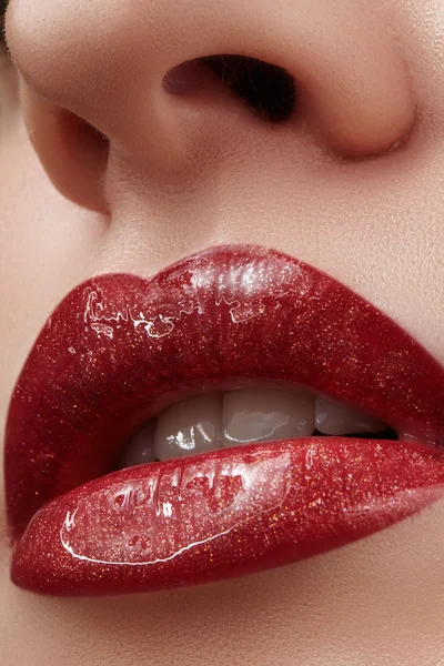 Close-up dari bibir perempuan dengan makeup yang cerah. Makro wajah wanita. Mode bibir make-up dengan gloss.Red lipgloss merah makeup pada bibir perempuan penuh — Stok Foto