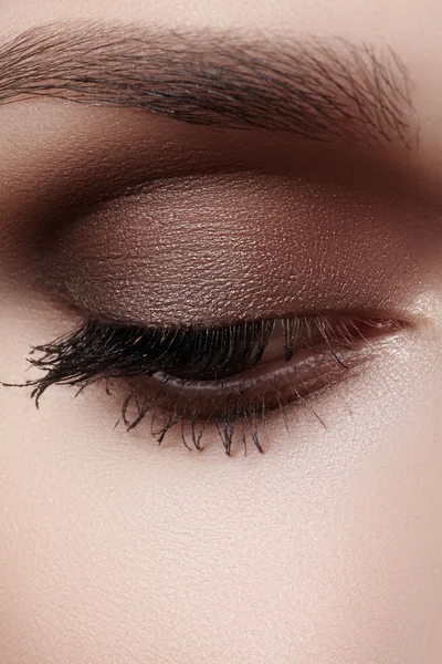 Hermoso macroplano de ojo femenino con maquillaje ahumado clásico. Forma perfecta de cejas, sombras marrones y pestañas largas. Cosméticos y maquillaje. Primer plano macro disparo de moda ojos ahumados visage — Foto de Stock