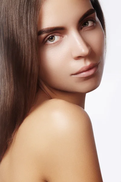 Hermosa mujer joven con la cara limpia, piel brillante, maquillaje natural de moda, cejas perfectas. Lindo peinado de bollo. Retrato de spa, cosméticos naturales, aspecto fresco saludable —  Fotos de Stock