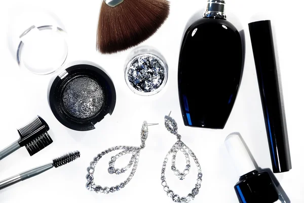 Samling med kosmetika verktyg. Mode kväll dekorativa set med svart nagellack, mascara, silver ögonskuggor, make-up tillbehör, lyx parfym och briljantar örhängen. Kosmetiska & makeup — Stockfoto