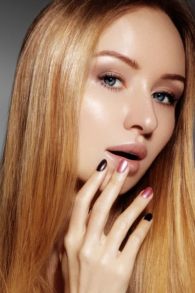 Hermosa mujer joven con la piel limpia, hermoso cabello liso brillante, maquillaje de moda. Maquillaje de glamour, cejas de forma perfecta. Retrato sexy rubio. Hermoso peinado suave. Esmalte de uñas brillante — Foto de Stock