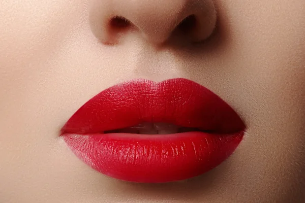 Primo piano delle labbra della donna con trucco rosso moda. Bella bocca femminile, labbra piene con trucco perfetto. Visiera classica. Parte del volto femminile. Macro shot di bel trucco su labbra piene . — Foto Stock