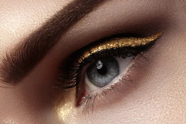 Schöne Makroaufnahme des weiblichen Auges mit zeremoniellem Make-up. perfekte Form der Augenbrauen, Eyeliner und hübsche Goldlinie auf dem Augenlid. Kosmetik und Make-up. Nahaufnahme Makroaufnahme der Mode funkelnde Visage — Stockfoto