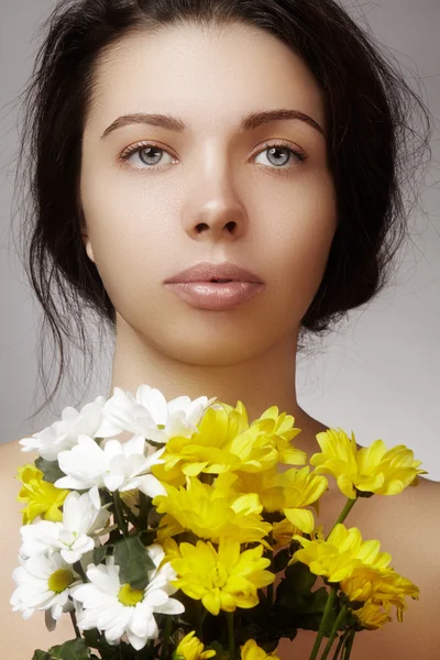 Hermosa mujer joven con una piel brillante perfecta y limpia, maquillaje de moda natural con flores de primavera. Mujer de cerca, aspecto de spa fresco — Foto de Stock