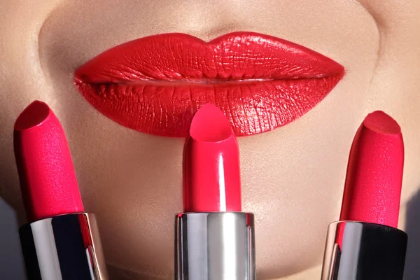 Primer plano de los labios de la mujer con maquillaje rojo de moda. Hermosa boca femenina, labios llenos con maquillaje perfecto. Parte de la cara femenina. Macro de maquillaje hermoso en los labios llenos. Elección de lápiz labial —  Fotos de Stock