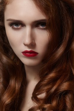 Temiz cilt, parlak kırmızı saçlar, moda makyaj güzel genç kadın. Glamour makyaj, mükemmel kan dudaklar. Kıvırcık saç modeli ile seksi zencefil kadın portre