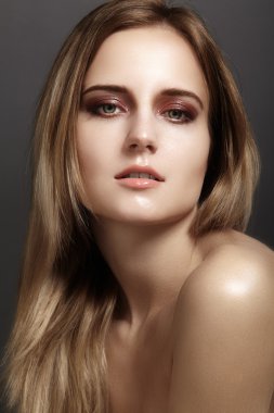 Parlak gözler ve dudaklar sima, koyu sarı renk uzun saçları olan güzel kadın. Temiz cilt, glamour moda makyaj Güzellik Portresi. Kozmetik, makyaj, saç modeli. Saç bakım
