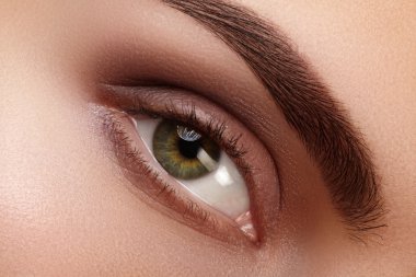 Doğal makyaj ile kadın gözü yeşil güzel makro çekim. Kaşlar, kahverengi kaptırdın ve uzun kirpiklerini mükemmel şekli. Kozmetik ve makyaj. Closeup makro moda dumanlı gözler sima vurdu.