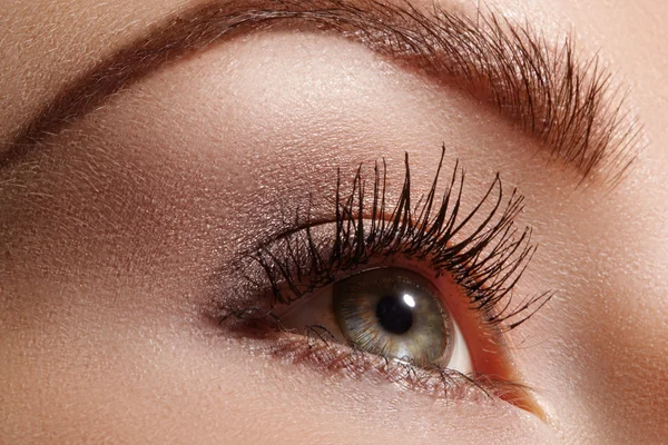 Hermoso macroplano de ojo femenino con maquillaje ceremonial. Forma perfecta de delineador de ojos y bonita línea azul en el párpado. Cosméticos y maquillaje. Primer plano macro disparo de la moda sparcle visage — Foto de Stock