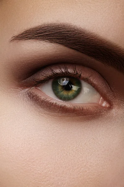 Mooie macro-opname van groene vrouwelijke oog met natuurlijke make-up. Perfecte vorm van wenkbrauwen, bruine eyeshadows en lange wimpers. Cosmetica en make-up. Close-up macro-opname van fashion rokerige ogen visage. — Stockfoto