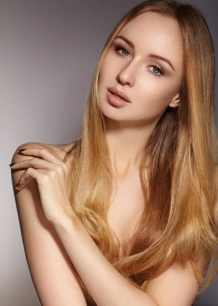 Hermosa mujer joven con la piel limpia, hermoso cabello liso brillante, maquillaje de moda. Maquillaje de glamour, cejas de forma perfecta. Retrato sexy rubio. Hermoso peinado suave. Esmalte de uñas brillante — Foto de Stock