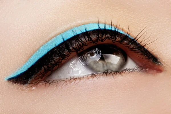 Beautiful macro shot of female eye with ceremonial makeup. Perfect shape of eyeliner and pretty blue line on eyelid. Cosmetics and make-up. Closeup macro shot of fashion sparcle visage — Stock Photo, Image