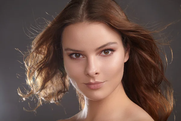 Belle jeune femme modèle avec des cheveux de couleur brune volant. Portrait de beauté avec peau propre, maquillage de mode éclatant et glamour. Maquillage, coiffure bouclée. Soins capillaires, maquillage. Portrait de beauté horizontal — Photo