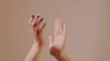 Kırmızı manikürlü kadın elleri ritim içinde nazikçe alkışlıyor. İfade, neşe ve güzelliği sembolize eder. Yaşam tarzı, vücut dili ve sanat kavramları için mükemmel. Alkışlar yakın çekim, onay. Halk alkışlıyor..