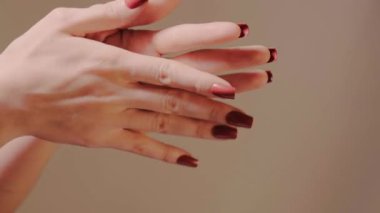 Uzun kırmızı tırnaklar ve lekesiz ojeler, manikür reklamları, moda gösterileri ve güzellik dersleri için hazırlanmış şehvetli bir tırnak uzunluğu sergileyerek el ele tutuşuyorlar..