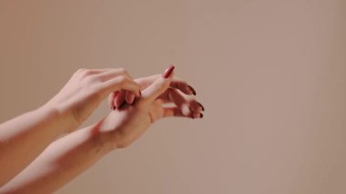 Kırmızı renkli şık manikürlü kadın ellerinin yakın çekimi. Kadın yeni manikürlü tırnaklarını gösteriyor. Tırnakların güzelliği. Klasik tarz, cilt bakımı. Güzellik, kozmetik ve moda reklamı için mükemmel.