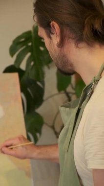 Handsome male artist mixing oil colors on pallet. Artwork painting process creation of picture masterpiece. Creative Art Studio leisure hobby profession concept, Master class in education paint school.