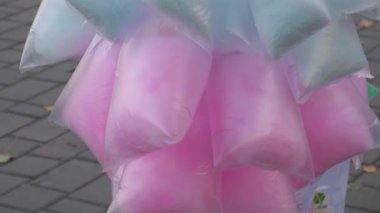 Plastik torbalarda renkli pamuk şeker. Çocuklar için tatlı sokak yemeği. Şeker satıcısı. Küçük işletmeler, girişimcilik, çocuklara gıda satışı. Tatil ve hafta sonu boş zaman ve eğlenceli aktiviteler.