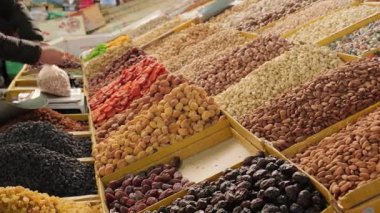 Pazar vitrininde fındık ve kurutulmuş meyveler, faal ticaretin altını çizmek, satıcıların doğal tatlılar sunduğu Orta Asya 'daki işlek yerel pazarda ürün satışları, çeşitli taze gıda ürünleri.