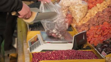 Çeşit çeşit fındık ve kurutulmuş meyve içeren büyük bir vitrin. Orta Asya 'daki yerel organik pazarında canlı bir sayaç. Çeşitli gıda ürünleri, doğal tatlılar. Ticaret, satış, iş.