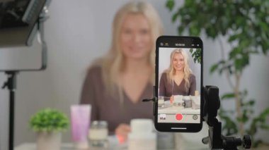 Güzellik uzmanı ya da makyaj spreyli vlogger yüzü ya da cilt bakımı tavsiyesi, kozmetik promosyon için içerik yaratmak ya da çevrimiçi yayın. Kadın özel ders, sosyal medya pazarlaması için ürün tutuyor.