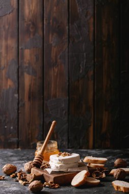 Koyu dokuda bal ve cevizle servis edilen keçi peyniri. Boşluğu kopyala