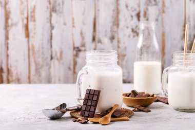 Beyaz desenli arkaplanda çikolata ile servis edilen vanilyalı milkshake.