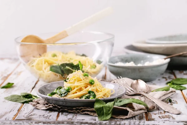 Italian food: Fresh home made tagliatelle vegetarian egg pasta Carbonara served with ricotta cheese and spinach over white wooden background