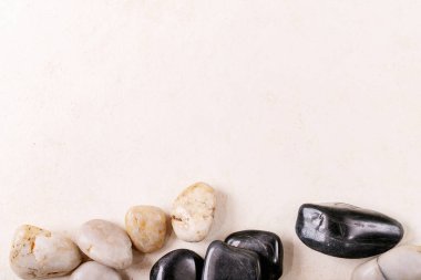 Beyaz, siyah dekoratif taşlar ve gri ahşap zemin üzerinde çakıl taşları. Yaratıcı yerleşim