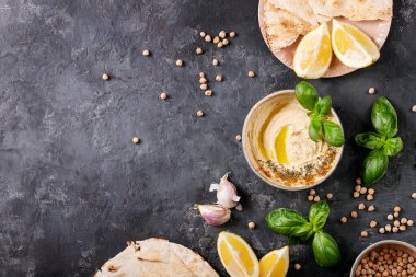 Zeytinyağlı humus, pide ekmeği ve seramik kasede limon, fesleğen ve bezelye ile servis edilen kimyon. Üst manzara, düz uzanma