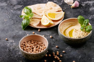 Zeytinyağlı humus, pide ekmeği ve seramik kasede limon, fesleğen ve bezelye ile servis edilen kimyon. Üst manzara, düz uzanma