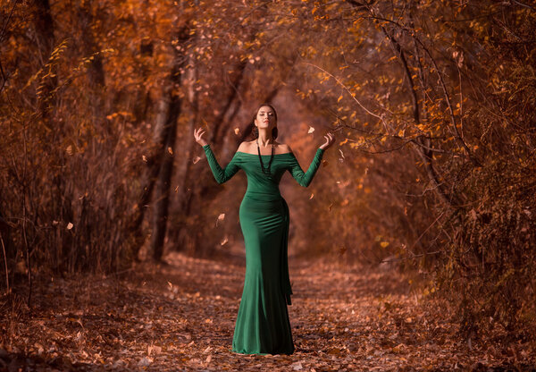 Lady in a luxury lush emerald dress ,fantastic shot,fairytale princess is walking in the autumn forest,fashionable toning,creative computer colors