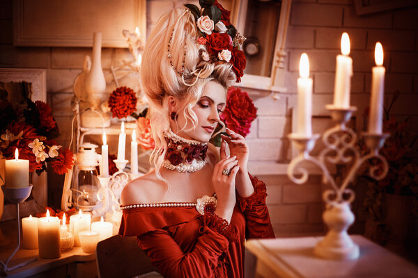 Portrait of a beautiful lady in a baroque style , vintage atmosphere with candles and flowers in the head , hip toning , creative color