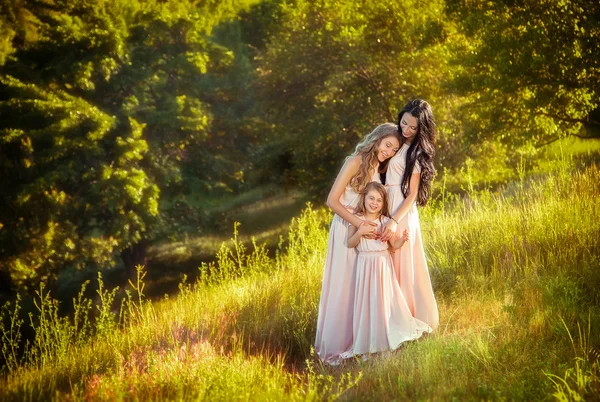 Мать нежно обнимает дочерей-красавиц в роскошных платьях . — стоковое фото