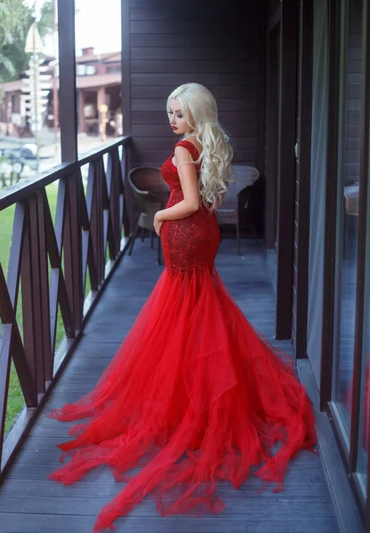 Szép szőke lány egy luxus piros ruha. — Stock Fotó