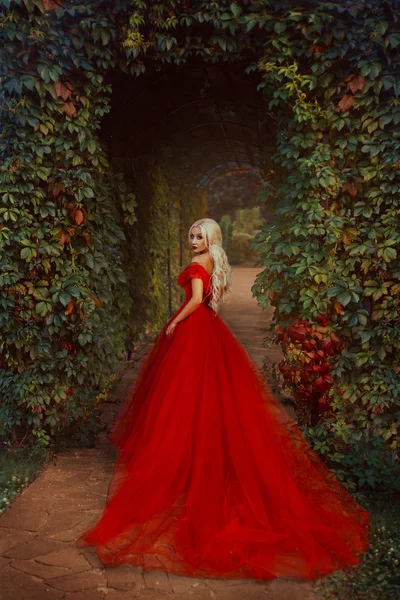 Belle fille blonde dans une robe rouge luxueuse . — Photo