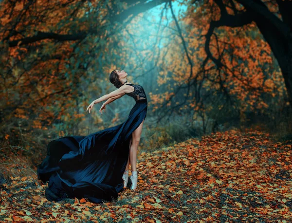 Fantasia fada bela mulher em um vestido de seda preta medieval dançando. Princesa menina na nebulosa floresta de outono. Arte de processamento de árvores amarelas luz mágica divina brilhante. Modelo de moda bailarina dançarina posando — Fotografia de Stock